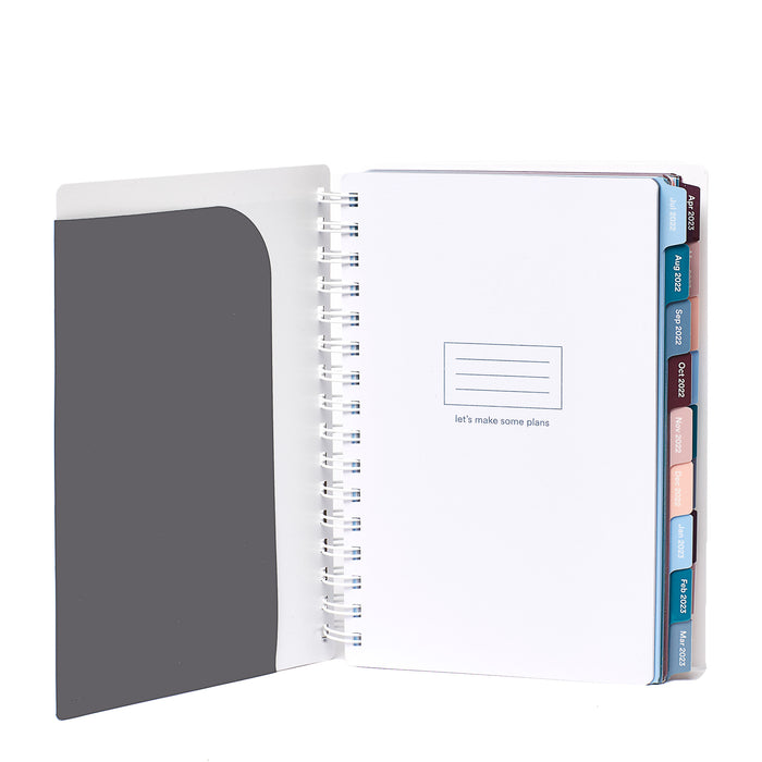 Open planner with inspirational quote and colored tabs on white background. (Dark Gray)