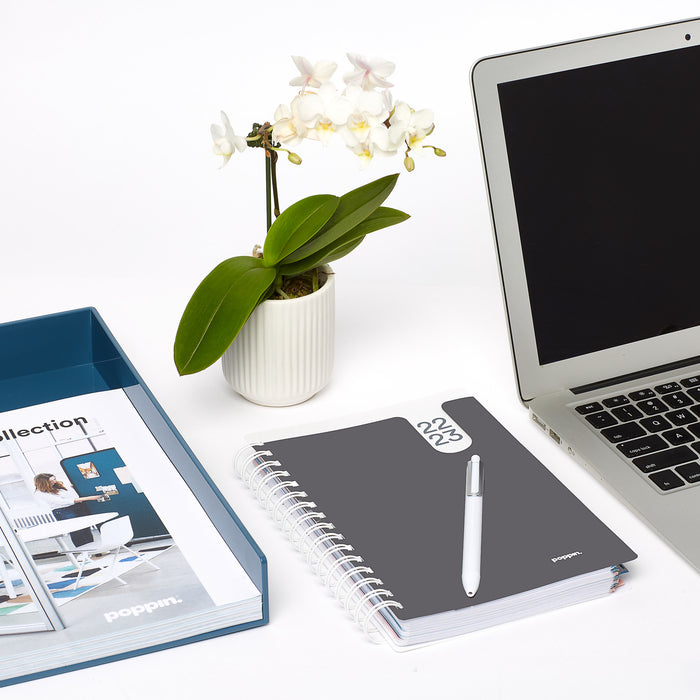 White orchid in pot beside laptop, notebook, and pen on a clean office (Dark Gray)