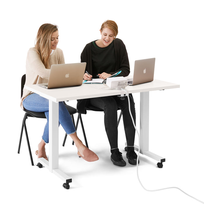 Two women working together at a white office desk with laptops. (White-47&quot;)
