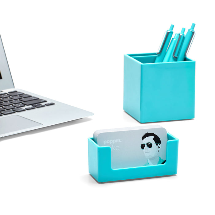 Modern minimalist office desk with laptop and turquoise stationery holder. (Aqua)