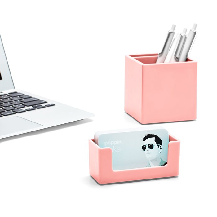 "Modern white laptop next to coral office supplies with pens and business cards on a (Blush)