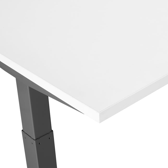 Close-up view of the corner of a modern white tabletop with a gray metal leg. (White-60&quot;)