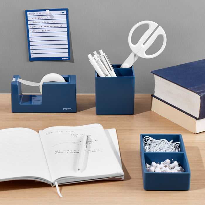 Organized desk with stationery supplies, notebooks, and clipboard on wooden surface. (Slate Blue)