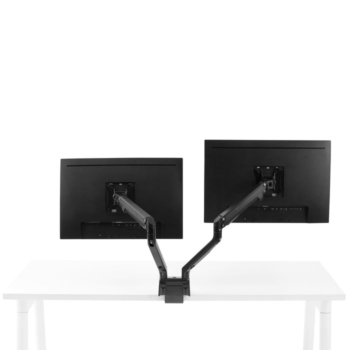 Dual monitor arms holding screens on white desk against a white background. (Black)