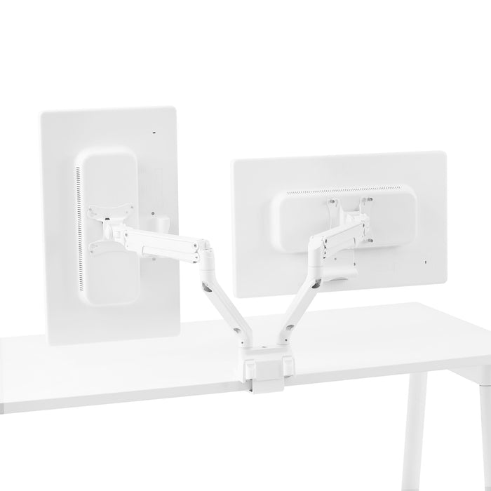 Dual white monitor arms supporting two monitors on a white desk against a white background. (White)