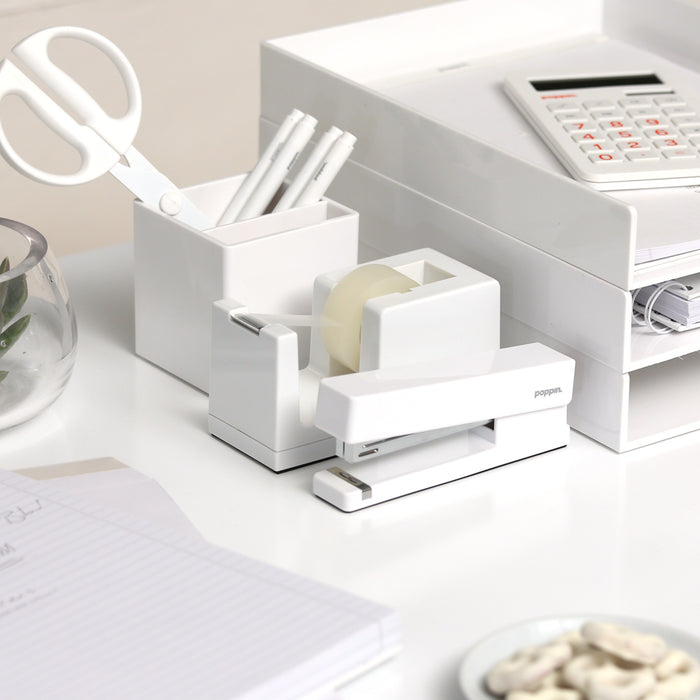 White office supplies including stapler, tape dispenser, and calculator on desk. (White)