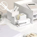 White office supplies including stapler, tape dispenser, and calculator on desk. (White)