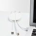 White cable organizer with USB cords on a desk beside a computer. (White)