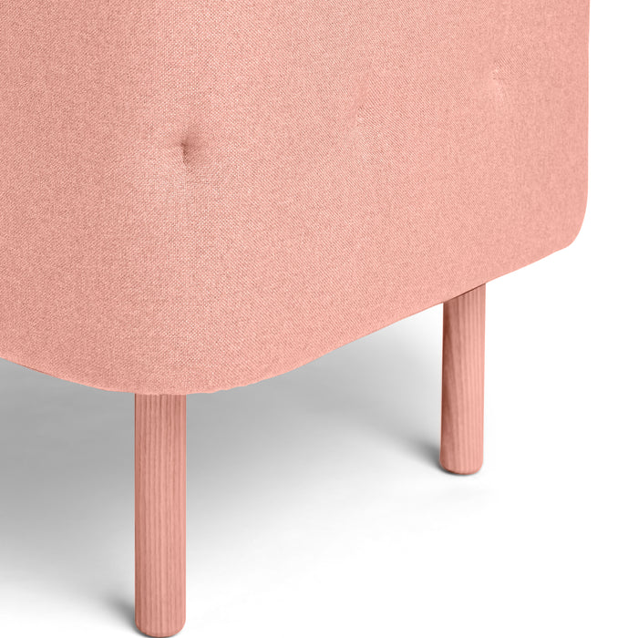 Close-up of a pink fabric ottoman with wooden legs on a white background. (Blush-Blush)(Gray-Blush)
