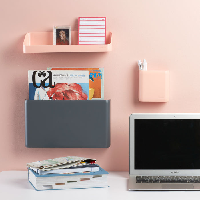 Modern home office with wall shelves, books, and MacBook on desk against a pink background. (Dark Gray)