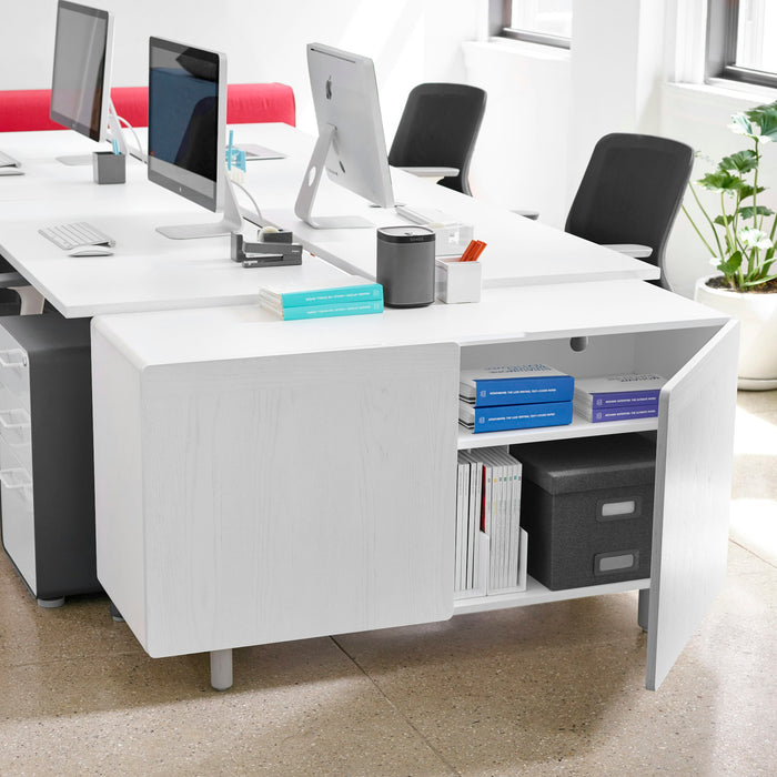 Modern white office desk with computers and organized supplies in a bright workspace. (White)