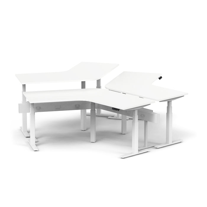 Two-tiered white ergonomic office desks with adjustable height settings. 