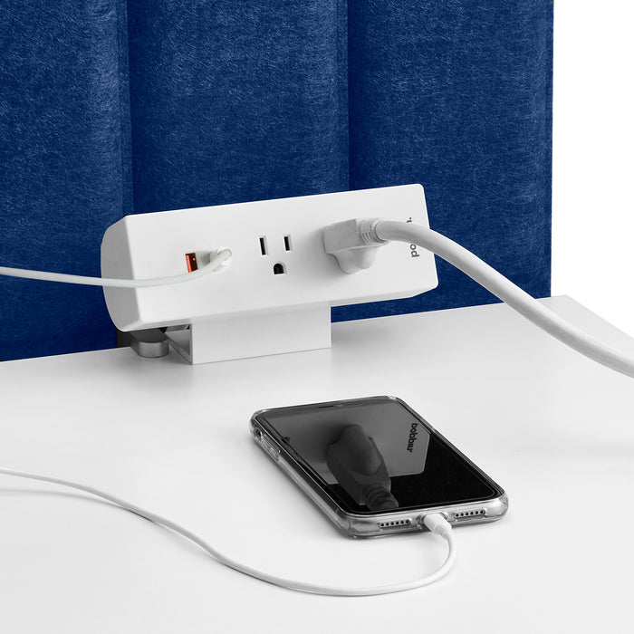Wall-mounted surge protector with USB ports charging a smartphone. 