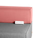 Modern grey couch with pink cushions and integrated USB charging ports. 