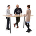 Three professionals standing and conversing around a high table in a modern office space. (Natural Oak-72&quot; x 36&quot;)(Natural Oak-72&quot; x 36&quot;)