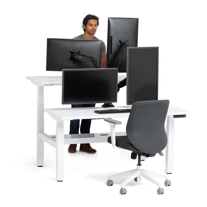 Man in modern office with adjustable standing desks and ergonomic chair. (White-57&quot;)