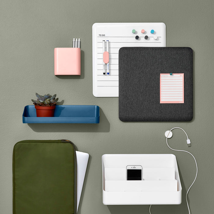 Modern wall-mounted organization accessories with notebooks and charging phone. 