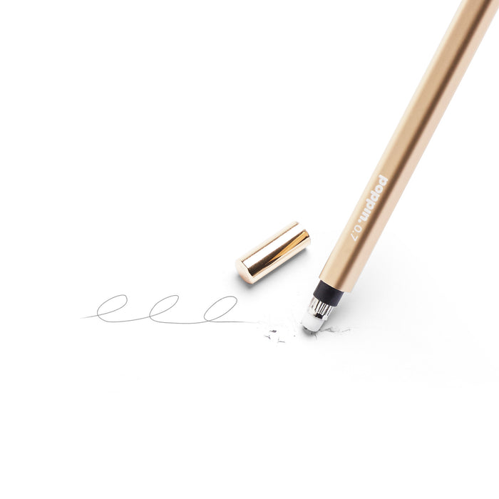 Gold pen with cap off writing a line on white background. 