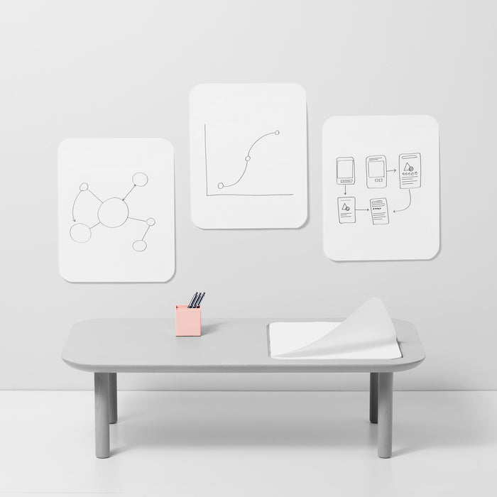 Minimalist office with whiteboard graphics, desk organizer, and bench on a gray background. 