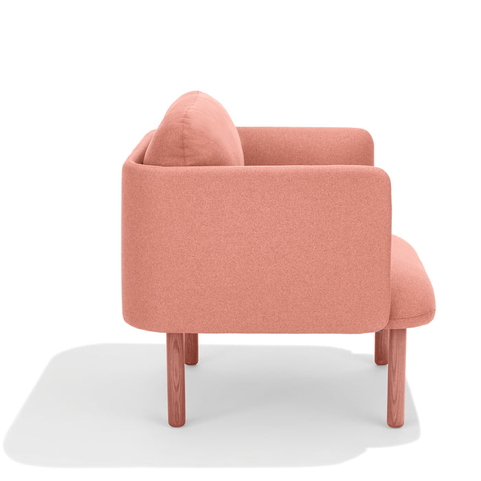 Modern coral pink armchair with wooden legs isolated on a white background. (Blush)