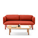 Modern red sofa with wooden legs and coffee table with books and stationery on white background. (Brick)