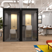 Modern private office pods with clear glass doors in an open-plan workspace. (Black)