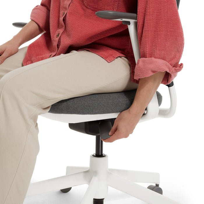 Person adjusting office chair height, demonstrating ergonomic seating adjustments. (Dorset Charcoal-White)