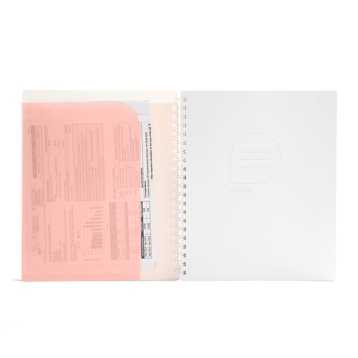 Open notebook with spiral binding beside translucent pink document folder on white background. (Blush-1 Subject)