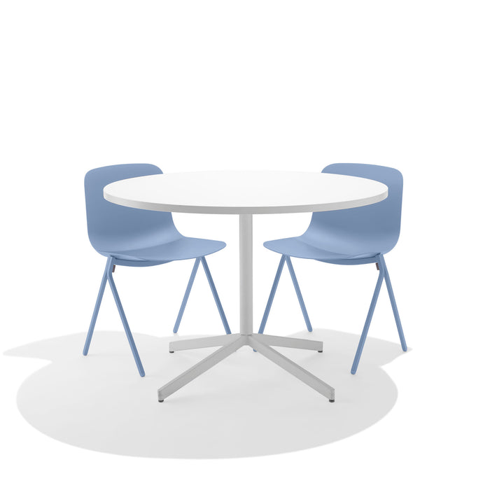Round white table with two blue chairs on a white background. (Sky)