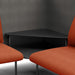 Modern black coffee table between two orange armchairs with grey background. (Brick-Dark Gray)