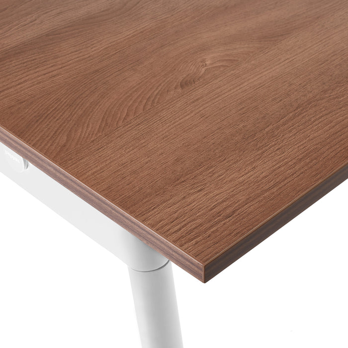 Close-up view of a wooden tabletop with a detailed wood grain and a white metal leg. (Walnut-72&quot; x 36&quot;)(Walnut-144&quot; x 36&quot;)