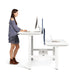 Woman standing at an adjustable desk working on a computer in an office setting. (White-57&quot;)(White-47&quot;)