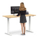 Woman standing at modern adjustable standing desk using computer (Natural Oak-60&quot;)