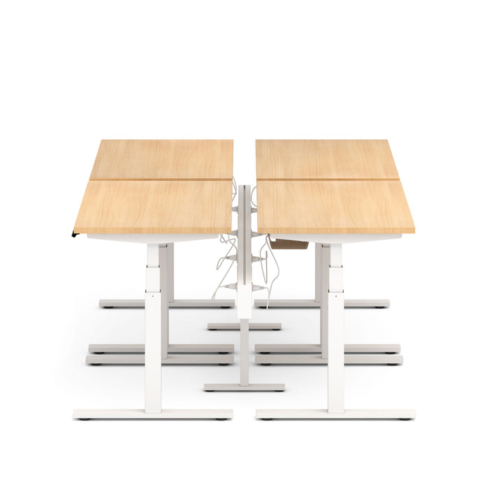 Dual sit-stand workstations with wooden tabletops and white frames against a white background. (Natural Oak-47&quot;)