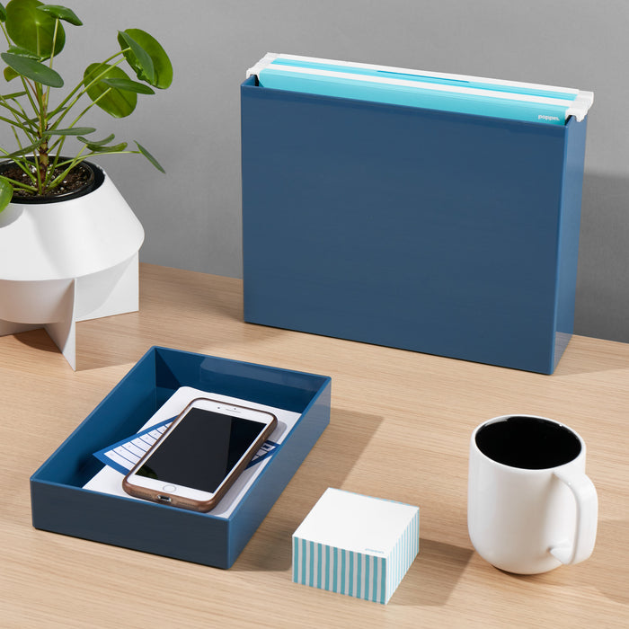 Modern desk with blue file organizer, smartphone in tray, black coffee mug, and (Slate Blue)