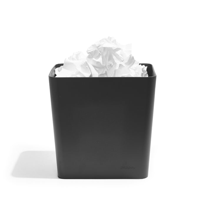 Black trash bin filled with crumpled paper on a white background. (Charcoal)