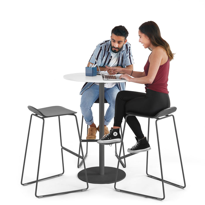 Two people collaborating over a laptop at a modern round table with stools. (White-Charcoal)