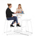 Two women smiling and chatting at a modern white round table with bar stools. (White-White)