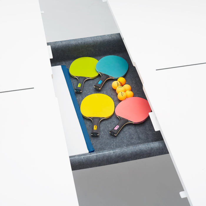 Four colorful ping pong paddles and balls on a table tennis table. (Slate Blue)