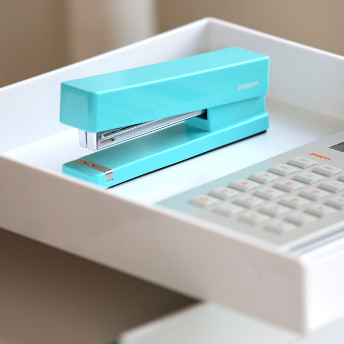 Turquoise Poppin stapler on white desk tray near calculator (Aqua)