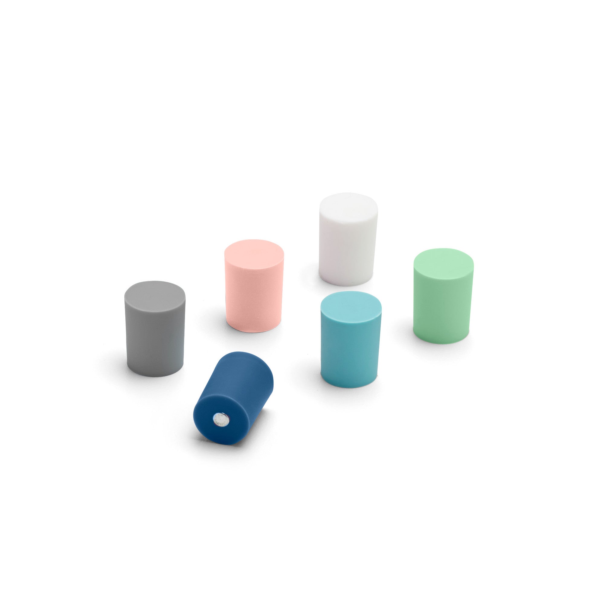 Variety of cylindrical bottles in different colors on white background. 