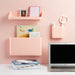 Pastel pink home office with floating shelves, MacBook, and stationery (Blush)