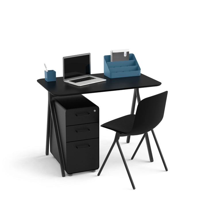 Modern home office setup with black desk, laptop, chair, and filing cabinet on a white background. (Black)