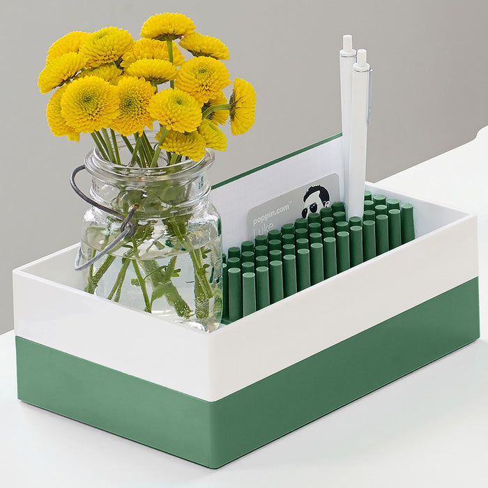 "Yellow flowers in a jar next to green pencils and notepad on a white (Sage)