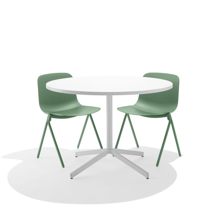 White round table with green chairs on a white background. (Sage)