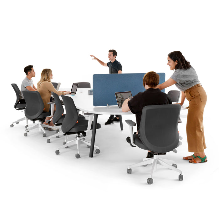 Team meeting in modern office with one person standing presenting to colleagues. (White-180&quot;)