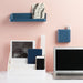 Organized modern desk workspace with laptop, smartphone, and wall-mounted shelves against a pink background. (Slate Blue)