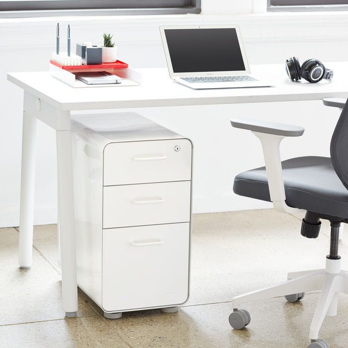 Modern home office setup with white desk, laptop, and ergonomic chair. (White-White)