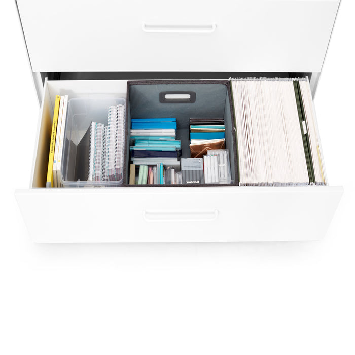 Top view of an organized office drawer with folders, documents, and supplies. (White)