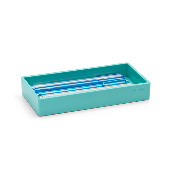 Blue pens in a light teal desk organizer tray on a white background. (Aqua)